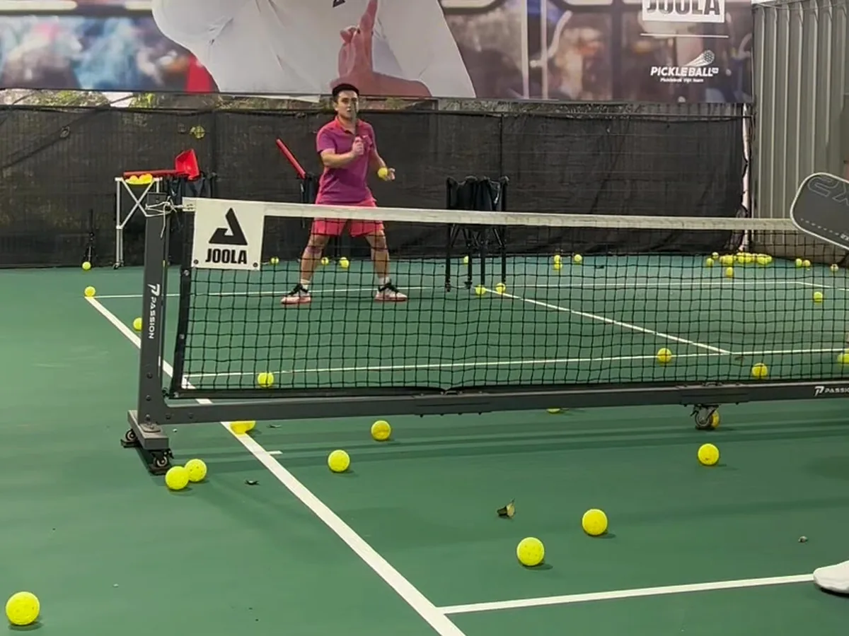 Hàng chục quả bóng pickleball màu vàng rải trên sân tập của MPA trong một buổi tập cấp bóng