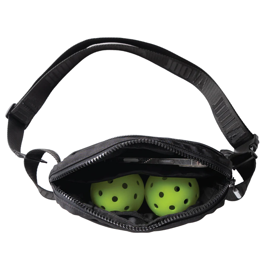 Túi đeo hông Everyday Belt Bag màu đen mở khoá, bên trong có hai quả bóng pickleball