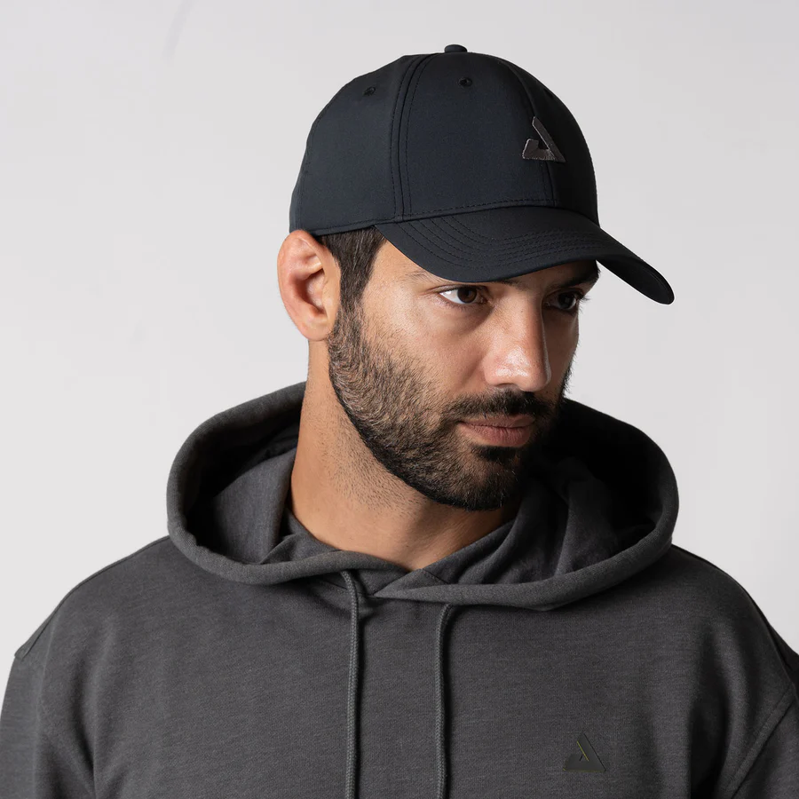 Người mẫu đội mũ lưỡi trai JOOLA Essential Cap màu đen, mặc áo hoodie xám
